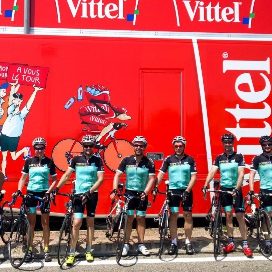 Topbike Riders line up with the TDF Caravan at a stage start during the Tour de France Paris Tour
